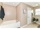 Bathroom featuring a soaking tub, tile floor, and white door at 7214 Morello Ln, Noblesville, IN 46062