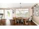 Sunlit dining area with a rustic wooden table, modern chairs, hardwood floors and large windows at 7214 Morello Ln, Noblesville, IN 46062