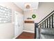 Inviting foyer with hardwood floors, staircase, welcome wreath, and a cozy seating area to enjoy at 7214 Morello Ln, Noblesville, IN 46062