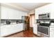 Well-equipped kitchen with stainless steel appliances, white cabinets, dark subway tile backsplash, and hardwood floors at 7214 Morello Ln, Noblesville, IN 46062