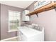 Bright laundry room featuring a modern washer and dryer, window with natural light, and a neutral color scheme at 7214 Morello Ln, Noblesville, IN 46062