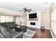Comfortable living room features a plush sectional, shiplap fireplace, and a stylish modern decor at 7214 Morello Ln, Noblesville, IN 46062