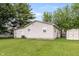 Home's exterior with lush green lawn, privacy fencing, mature trees, and a storage shed at 724 Alexander St, Greenwood, IN 46143