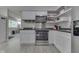 Compact kitchen with white cabinets, stainless steel appliances, and open shelving at 724 Alexander St, Greenwood, IN 46143