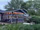 View of the home's rear exterior highlighting an enclosed sunroom, patio area, and hot tub at 75 Byram Blvd, Martinsville, IN 46151