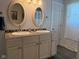 Bathroom featuring a double vanity with matching mirrors, neutral walls, and tiled floors at 75 Byram Blvd, Martinsville, IN 46151