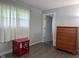 Bright bedroom featuring a dresser, side table, neutral walls, with a white door leading to an adjacent room at 75 Byram Blvd, Martinsville, IN 46151