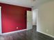 A bedroom with red accent wall, hardwood floors, and a doorway leading to another room at 75 Byram Blvd, Martinsville, IN 46151