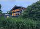 Rear exterior view of the house with sunroom addition and lush foliage surrounding the property at 75 Byram Blvd, Martinsville, IN 46151