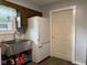 Laundry room featuring stainless steel sink, next to the refrigerator and a door at 75 Byram Blvd, Martinsville, IN 46151