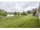 Expansive backyard with a pond view, mature trees, and a classic black chain fence at 7632 Sea Crest N Way, Noblesville, IN 46062