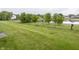 Spacious backyard with lush green grass, a pond view, and a black fence at 7632 Sea Crest N Way, Noblesville, IN 46062