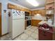 Bright kitchen with oak cabinets, white appliances, and tile flooring at 7632 Sea Crest N Way, Noblesville, IN 46062