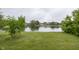 Peaceful pond view with lush trees in the background, framed by the well-kept green grass at 7632 Sea Crest N Way, Noblesville, IN 46062