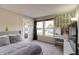 Cozy bedroom with neutral carpet, a gray upholstered headboard, and natural light from the window at 8148 Gathering Cir, Indianapolis, IN 46259