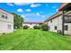 Wide exterior shot showing green grass, buildings, shrubs, and trees at 8545 La Corrida Ct, Indianapolis, IN 46227