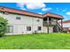 Exterior back view of home showing back yard, windows, red roof, and stairs to balcony at 8545 La Corrida Ct, Indianapolis, IN 46227