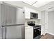 Renovated kitchen with stainless steel appliances, white cabinets and modern fixtures at 8545 La Corrida Ct, Indianapolis, IN 46227