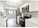 Bright kitchen with stainless steel appliances, white cabinets, and view into dining area at 8545 La Corrida Ct, Indianapolis, IN 46227