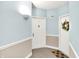 Bright hallway featuring neutral-toned walls and carpet, leading to unit doors at 8720 Yardley Ct # 108, Indianapolis, IN 46268