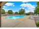 Community pool surrounded by lounge chairs, trees, and a gazebo on a sunny day at 8720 Yardley Ct # 108, Indianapolis, IN 46268