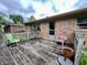 A weathered wood back deck shows chairs, a door, brick, and an exterior view of the property at 902 N Bauman St, Indianapolis, IN 46214