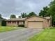 Charming single-story home featuring brick facade, attached garage, and well-manicured front lawn at 902 N Bauman St, Indianapolis, IN 46214
