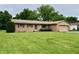 Charming single-story home featuring brick facade, attached garage, and well-manicured front lawn at 902 N Bauman St, Indianapolis, IN 46214