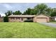 Ranch home with brick facade, attached garage and manicured lawn at 902 N Bauman St, Indianapolis, IN 46214