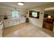 Functional kitchen with neutral colored cabinets and linoleum floors with an opening to the living room at 902 N Bauman St, Indianapolis, IN 46214