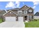 Beautiful two-story home featuring a brick and siding facade, a three-car garage, and a well-manicured lawn at 928 Ridge Rock Ln, Bargersville, IN 46106