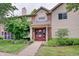 Inviting exterior of a two-story home with a brick facade and red double-door entry framed by mature landscaping at 1074 Timber Creek Dr # 8, Carmel, IN 46032