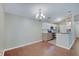 Open-concept space with a chandelier above the dining space and a view of the modern kitchen with stainless steel appliances at 1074 Timber Creek Dr # 8, Carmel, IN 46032