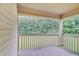 Covered porch overlooks backyard with wooden railing and view of mature trees at 1074 Timber Creek Dr # 8, Carmel, IN 46032