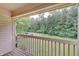 Covered porch overlooks backyard with wooden railing and view of mature trees at 1074 Timber Creek Dr # 8, Carmel, IN 46032