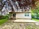 Backyard features a small deck, a concrete patio, chain link fence, and lush trees at 10922 Snowdrop Way, Indianapolis, IN 46235