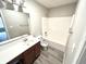 Bathroom featuring a large vanity, mirror, tile floors, and a shower-tub combination at 10922 Snowdrop Way, Indianapolis, IN 46235