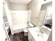 Neutral bathroom featuring a bathtub, tile surround, modern vanity, and decorative mirror at 10922 Snowdrop Way, Indianapolis, IN 46235