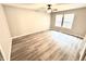 Bedroom featuring hardwood floors, a ceiling fan, and a large window providing natural light at 10922 Snowdrop Way, Indianapolis, IN 46235