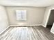 Bright bedroom featuring wood-look flooring, fresh paint, and a window for natural light at 10922 Snowdrop Way, Indianapolis, IN 46235
