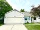 Charming single-story home featuring a two-car garage, manicured lawn, and lush surrounding trees at 10922 Snowdrop Way, Indianapolis, IN 46235