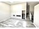 Bright living room featuring sleek, wood-look flooring, neutral paint, and an open staircase at 10922 Snowdrop Way, Indianapolis, IN 46235