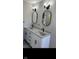 Bathroom featuring a double sink vanity with granite countertop, modern fixtures, and oval mirrors at 1101 E 25Th St, Muncie, IN 47302