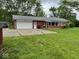 Side view of a well-maintained red brick home featuring an attached garage and a well-kept lawn at 1101 E 25Th St, Muncie, IN 47302