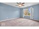 Carpeted bedroom with large window and ceiling fan, offering ample natural light and comfort at 11254 N Sashing Way, Monrovia, IN 46157