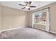 Neutral bedroom with a ceiling fan and a large window offering views of the trees outside at 11254 N Sashing Way, Monrovia, IN 46157