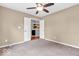 Neutral bedroom with a ceiling fan and carpeted floors, offering a view of the kitchen at 11254 N Sashing Way, Monrovia, IN 46157