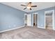 Spacious primary bedroom with ensuite bathroom and carpet flooring, painted a tranquil blue at 11254 N Sashing Way, Monrovia, IN 46157