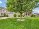 Well-maintained front yard with lush green grass, mature trees, and manicured landscaping at 11254 N Sashing Way, Monrovia, IN 46157