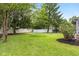 Spacious backyard with lush green lawn, privacy fence, mature trees, and outdoor seating area at 1127 Junco Dr, Columbus, IN 47203